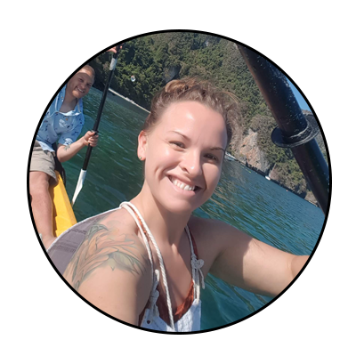 A smiling woman on a kayak in the water. Credit: Jess Clyburn